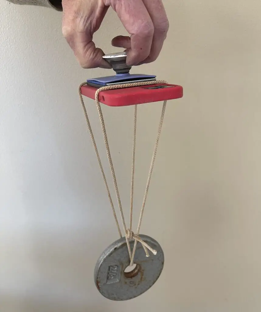 Popwallet suspended on phone with 2.5 lb weight hanging from it